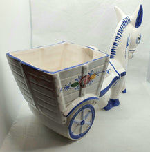 Last inn bildet i Galleri-visningsprogrammet, Stor esel med vogn i porselen. Vognen brukes som blomsterpotte.

